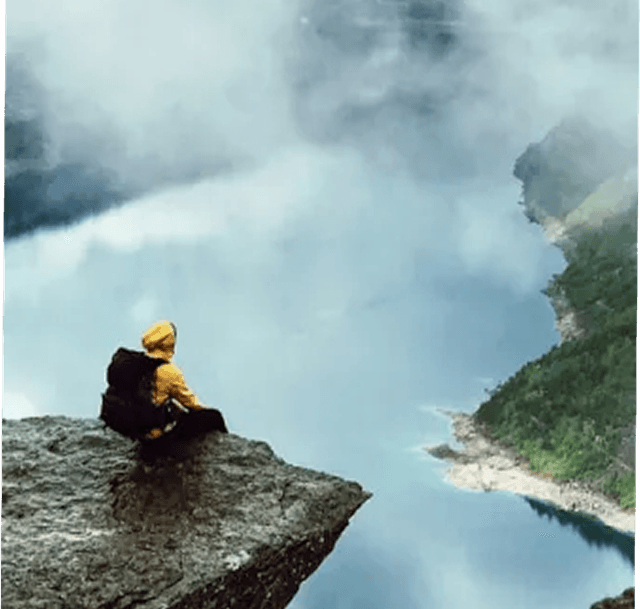 Person sitting on rock near hot spring